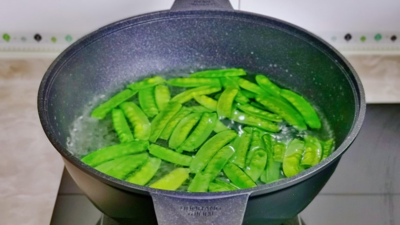 炒口蘑,锅中加水,盐烧开,下荷兰豆煮40秒。