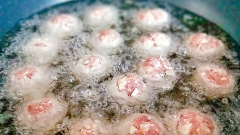 红烧肉丸子,起油锅,油温7成时一个一个的将丸子下锅,中小火炸丸子,炸至金黄即可出锅。