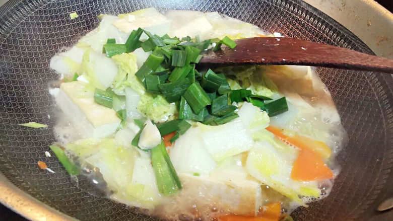 白菜炒豆腐,煮至收汁后,加盐,鸡精调味,青蒜苗片也放进来