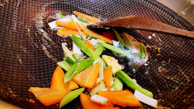 白菜炒豆腐,锅中放油,下青蒜苗与红萝卜片炒香