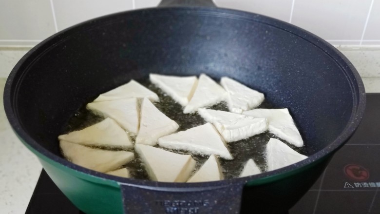 白菜炒豆腐,锅里放少许食用油,油热依次码入豆腐块,开中火慢慢煎,不要翻动。