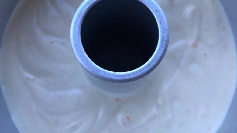 香橙戚风,震一下模具,稍抹平表面。