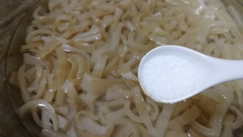 自制猪皮冻,放入温水里,加盐搓洗,把油脂搓掉,换水直到水变清澈。