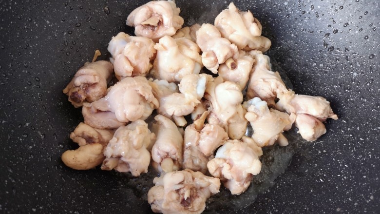 啤酒鸡翅根,炒锅内倒适量的食用油烧热,下入鸡翅根翻炒至表面微微焦黄。