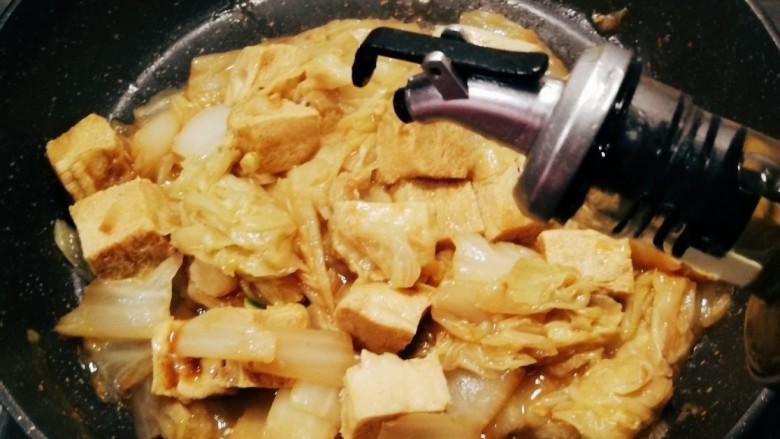 白菜炒豆腐,汤汁变少变浓稠,淋入芝麻油增香。