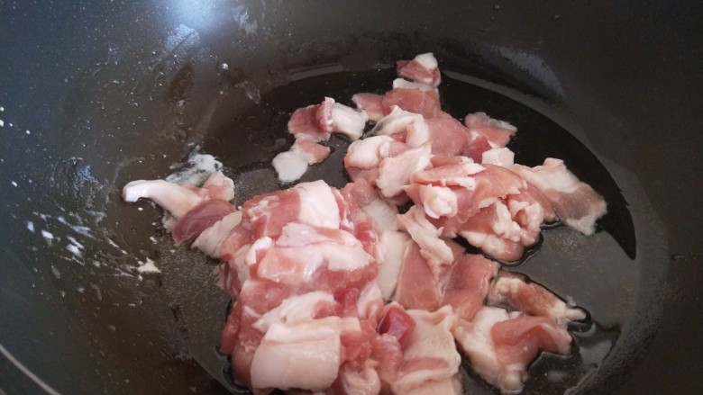 红烧米豆腐,五花肉切成片,放入锅中炒干出油。