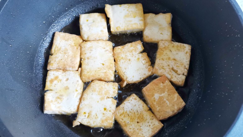白菜炒豆腐,热锅入油,放入豆腐煎至两面金黄盛出。