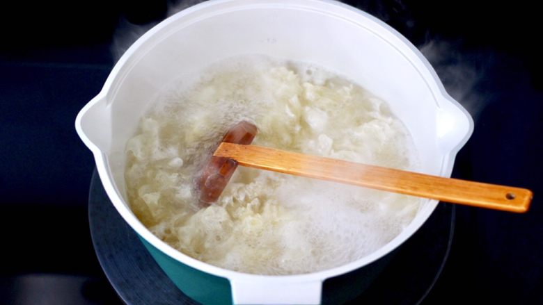 苹果金桔银耳羹,锅中倒入适量的清水,泡发好的银耳,去掉根部后撕成小朵,放入锅中大火烧开。