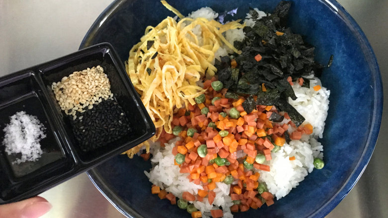 午餐肉饭团,把米饭、配菜全部放入大碗中,再放盐和黑白芝麻