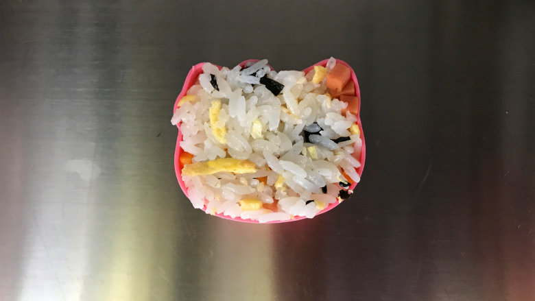 午餐肉饭团,在饭团模具中,舀入适量拌好的米饭