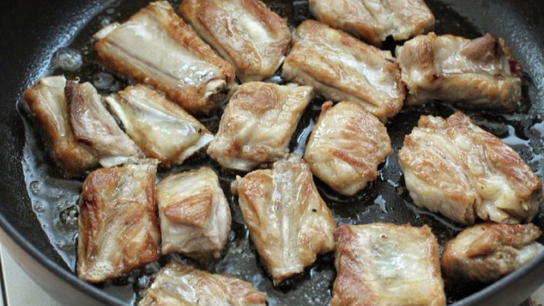 红烧土豆排骨,锅中放少许油烧热,将排骨放入锅中小火煎至两面焦黄色。