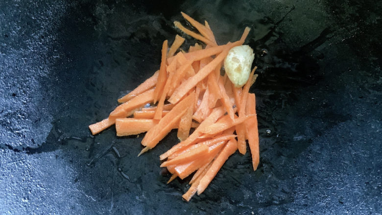油豆腐炒青椒,将胡萝卜加入其中,翻炒至变软