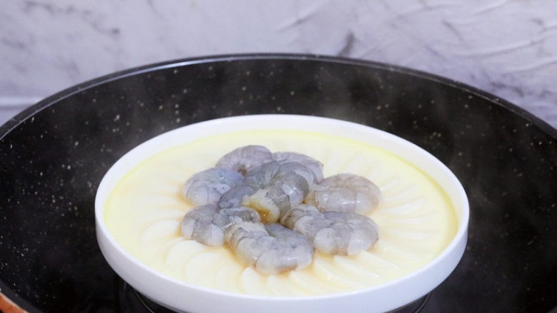 虾仁日本豆腐,将腌制的虾仁摆入盘中中间,再放回锅中,继续蒸5分钟