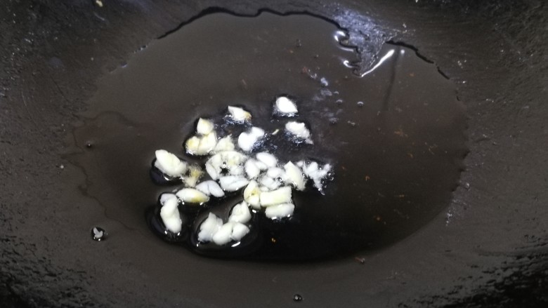 番茄花菜,热锅加少许油,放入蒜末,文火炒香。