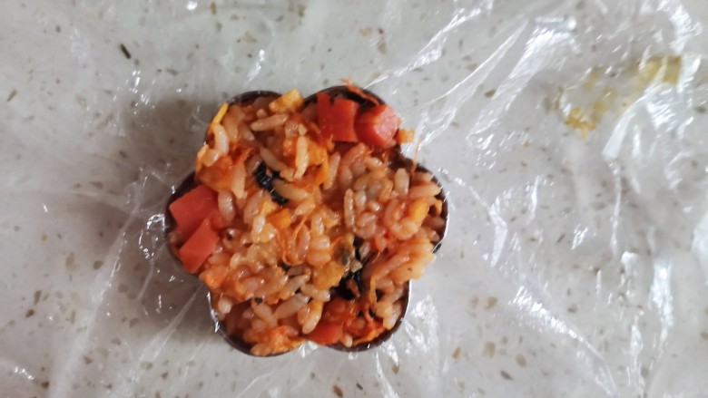 午餐肉饭团,模具里铺上保鲜膜,取适量的米饭压实,再倒扣出来了