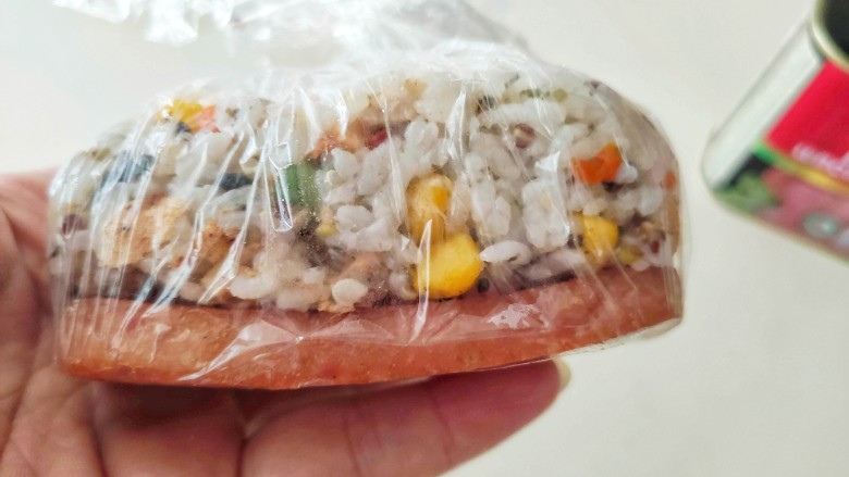 午餐肉饭团,保鲜膜整个取出来,然后再收口拧紧一下。