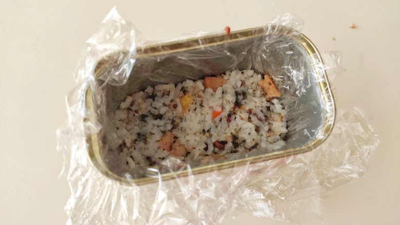 午餐肉饭团,把保鲜膜放在午餐肉的盒子里面,底部放一片午餐肉