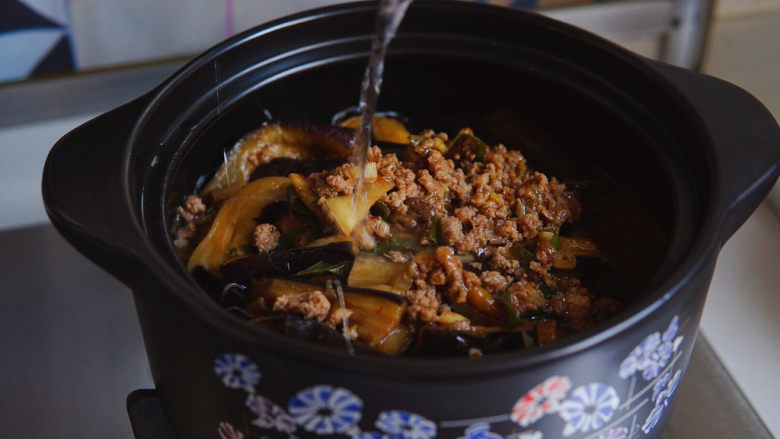 茄子粉丝煲,加一小碗水,加盖焖炖五分钟,出锅前,撒上红绿椒圈。