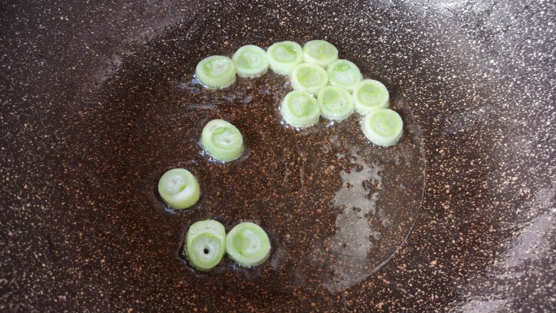 莲藕炒肉片,锅里留余油继续烧热,下入葱段炝香。