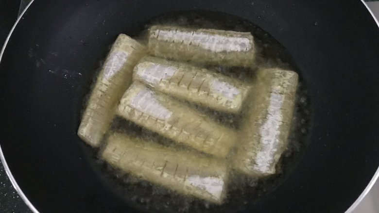 干煎带鱼,平底锅中倒稍多些菜籽油,烧热后放入带鱼段