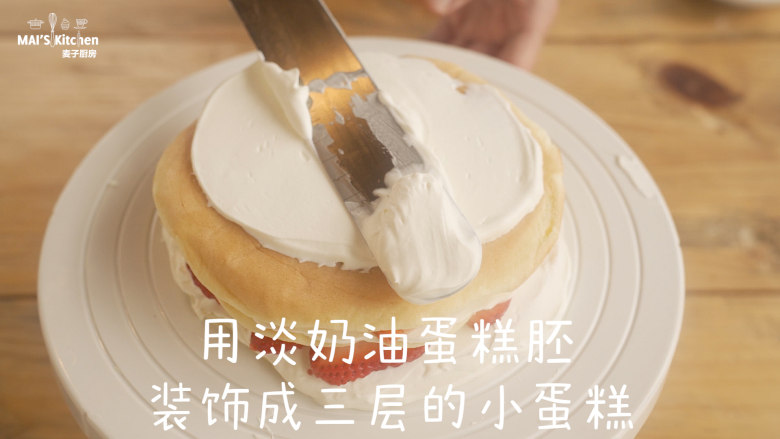 用小红锅给孩子做生日蛋糕,用淡奶油将蛋糕胚装饰成三层的小蛋糕,蛋糕胚中间放上<a style='color:red;display:inline-block;' href='/shicai/ 592'>草莓</a>薄片。