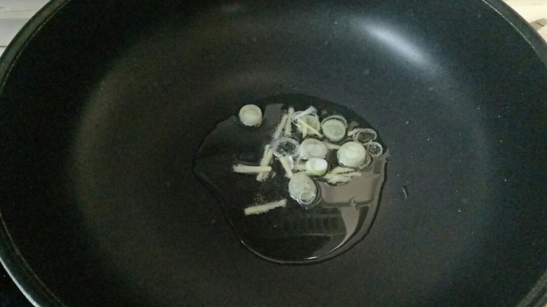 三鲜豆腐,炒锅中加入适量花生油烧热,放入葱花姜丝煸炒出香味