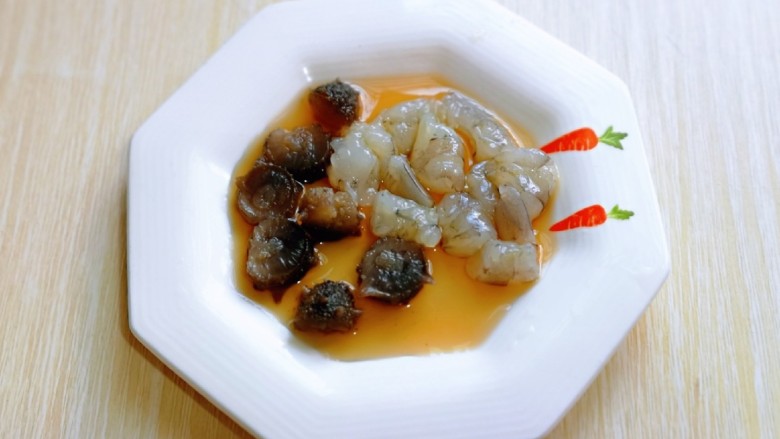三鲜豆腐,切好的海参与虾仁放入盘中,加入<a style='color:red;display:inline-block;' href='/shicai/ 718'>料酒</a>腌制10分钟。