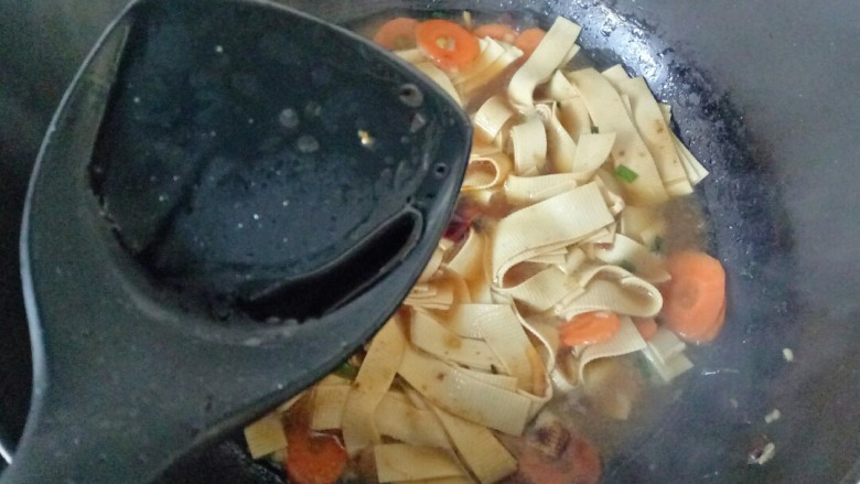 红烧豆腐皮,加入<a style='color:red;display:inline-block;' href='/shicai/ 762'>老抽</a>,翻拌均匀,盖上锅盖焖煮至汤汁变少