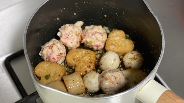 香辣口水火锅丸子,把调味料和各种丸子拌匀,装盘后再撒一些葱花点缀即可。