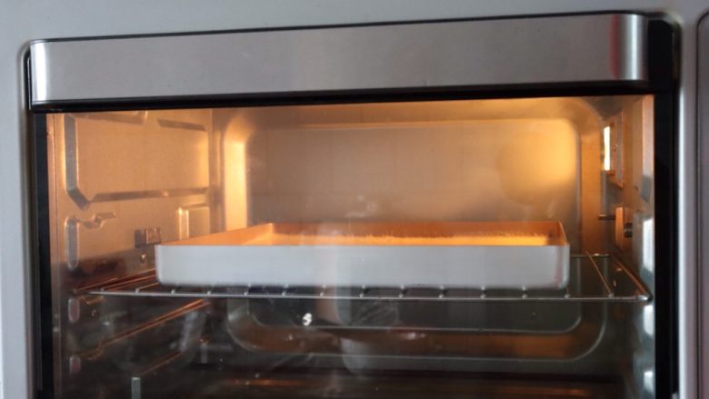 草莓香草奶油蛋糕卷,烤箱上下火170°C预热10分钟,把装入蛋糕糊的烤盘放入烤箱中层上下火170°C烘烤20分钟^o^