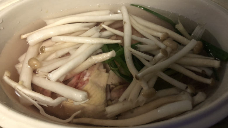 西红柿豆腐汤,放入姜片、葱结、铺上<a style='color:red;display:inline-block;' href='/shicai/ 268'>白玉菇</a>,倒入清水。