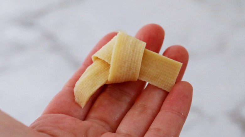 红烧豆腐皮,将千张切成条状,再打个结,如图所示