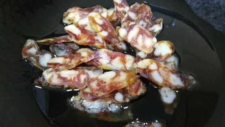 蒜苔炒腊肠,热锅凉油,不等油热放入腊肠。