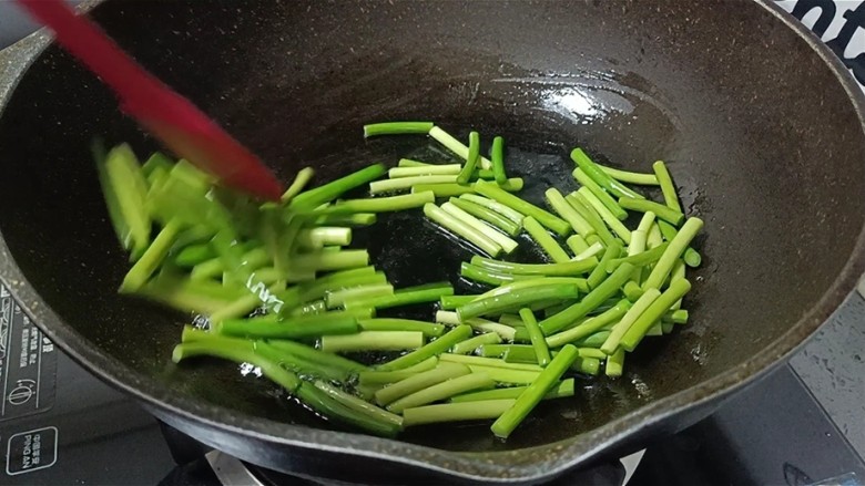 蒜苔炒腊肠,倒入蒜薹快速翻炒均匀制蒜苔起皱。