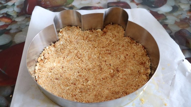 小熊维尼芒果慕斯蛋糕,搅拌好的饼干倒入模具中,用勺子把饼干压实,放入冰箱冷藏^o^
