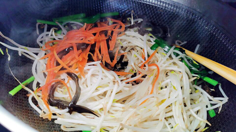 绿豆芽炒韭菜,炒去表面水分的豆芽及木耳,红萝卜丝一起下锅