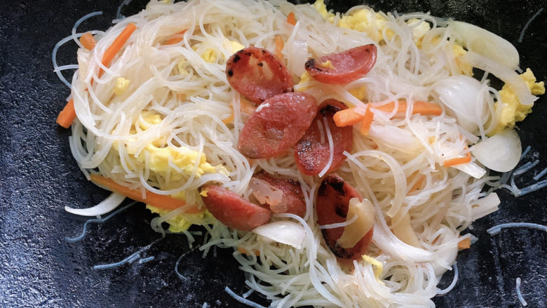 鸡蛋炒粉丝,并加入腊肠片,再炒15s出锅