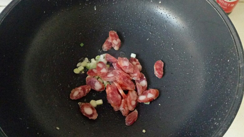 腊肠炒蛋,加入腊肠片,小火翻炒至透明