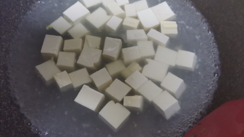 香辣下饭~麻婆豆腐,水开下入豆腐焯水2分钟,去除豆腥味,捞出控干水分备用