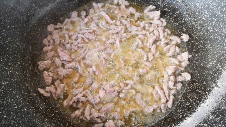 孜然羊肉炒饭,炒锅内一次性倒入够炒饭用的食用油,下入羊肉大火翻炒至变色。