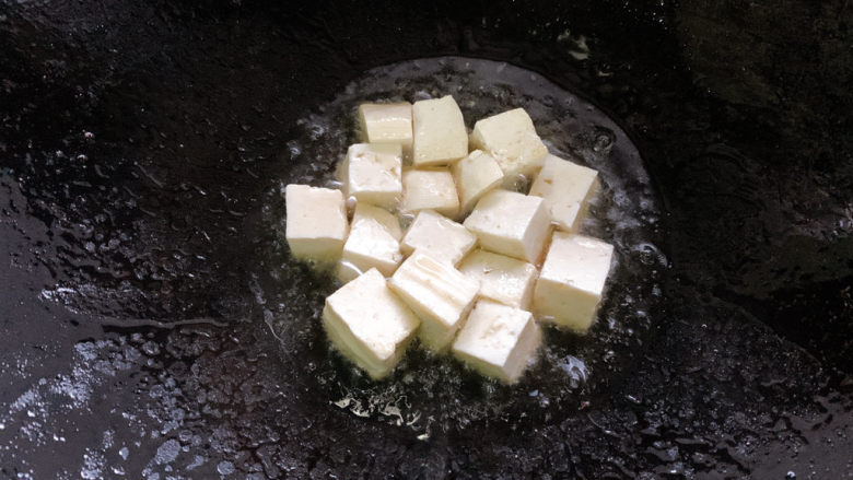 三鲜豆腐,加入豆腐块小火先煎一煎,煎制每面金黄,捞出备用。