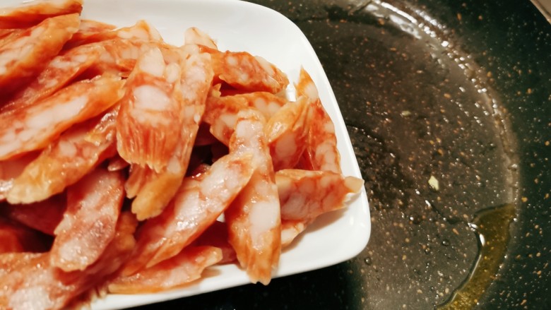 腊肠炒蛋,锅中留下底油继续加热,放入腊肠。