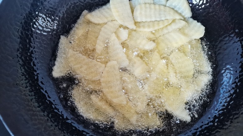洋葱炒土豆片,锅里倒入稍多点的油,油热放入土豆片炸软