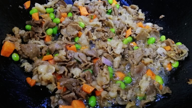 孜然羊肉炒饭,放胡萝卜丁,毛豆粒,文火炒匀。