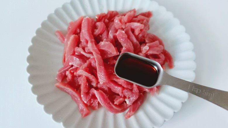 青椒炒牛肉,牛肉放在盘子里加上生抽一勺。