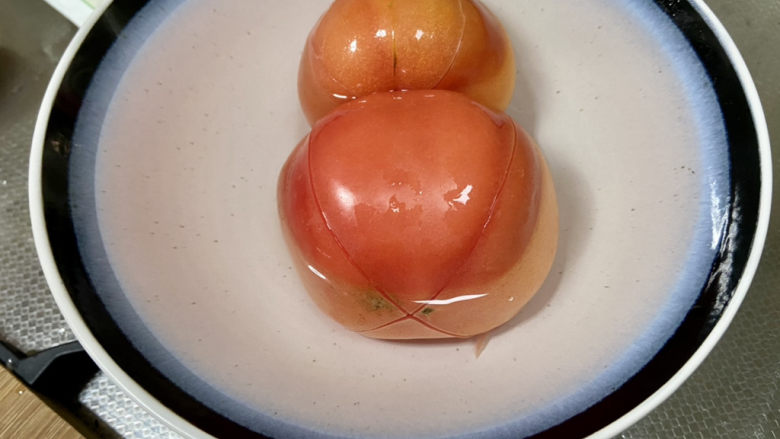 西红柿豆腐汤➕番茄香菇内脂豆腐汤,表面化十字花刀,加开水浸泡三分钟,方便剥皮