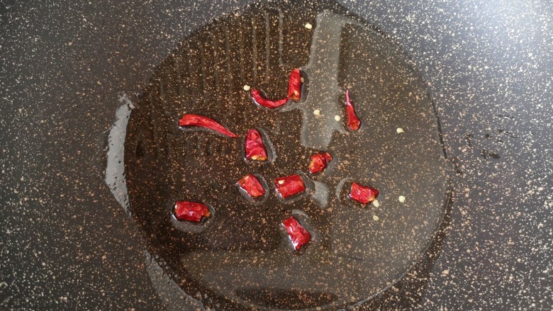洋葱炒土豆片,炒锅内倒适量的食用油烧热,下入干红辣椒炝香。