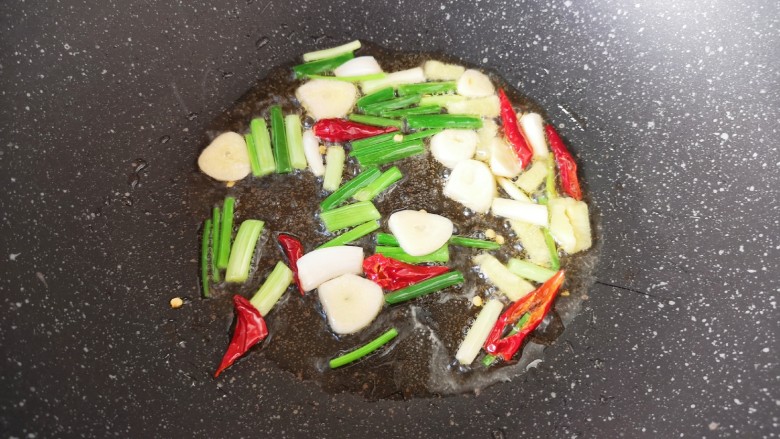 红烧豆腐皮,炒锅内倒适量的食用油烧热,下入葱姜蒜和干红辣椒炒香。