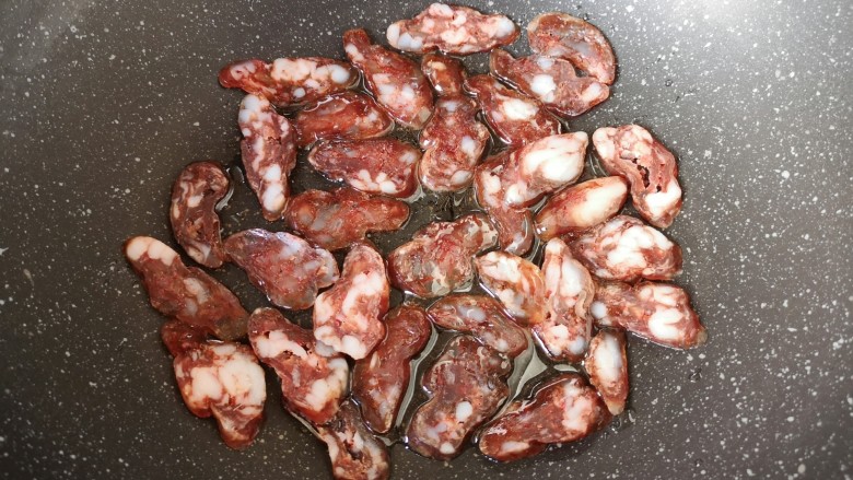 腊肠炒蛋,炒锅内倒适量食用油,码入腊肠片。