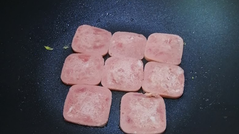 餐蛋三文治,热锅入油,加入午餐肉,煎至一面金黄
